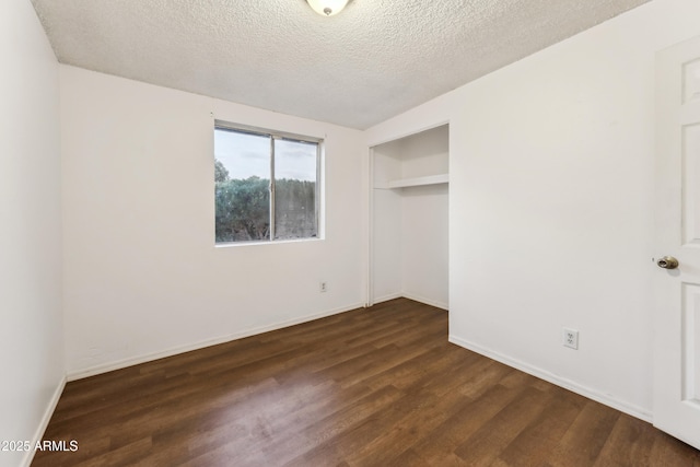 unfurnished bedroom with dark wood-type flooring, a textured ceiling, and a closet