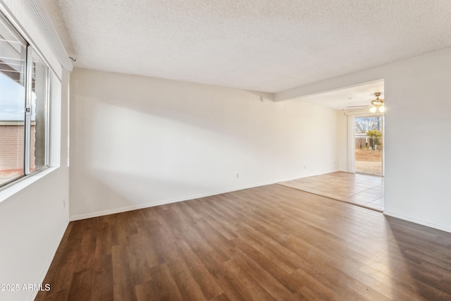 empty room featuring wood-type flooring, ceiling fan, and a textured ceiling