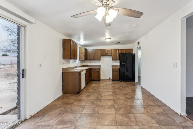 kitchen with sink, black fridge, light tile patterned floors, dishwasher, and ceiling fan