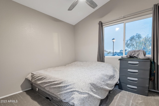 bedroom with ceiling fan, lofted ceiling, and dark carpet