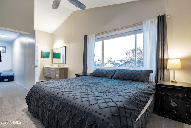 carpeted bedroom with ensuite bathroom, ceiling fan, and vaulted ceiling