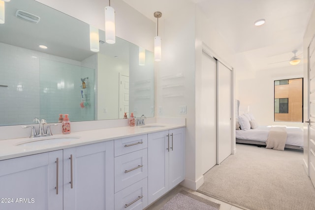 bathroom with a tile shower and vanity