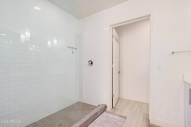 bathroom featuring hardwood / wood-style floors, vanity, and tiled shower