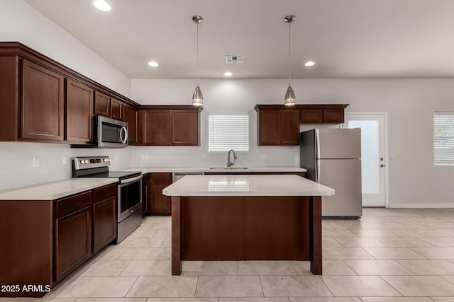 2000 N 36th St Unit 10, Phoenix, AZ 85008 - kitchen featuring appliances with stainless steel finishes, a center island, healthy amount of natural light, light tile patterned floors, and recessed lighting