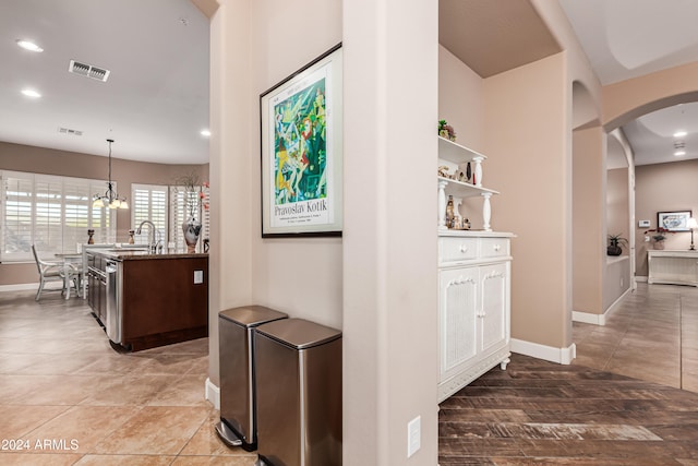 hallway with sink and an inviting chandelier