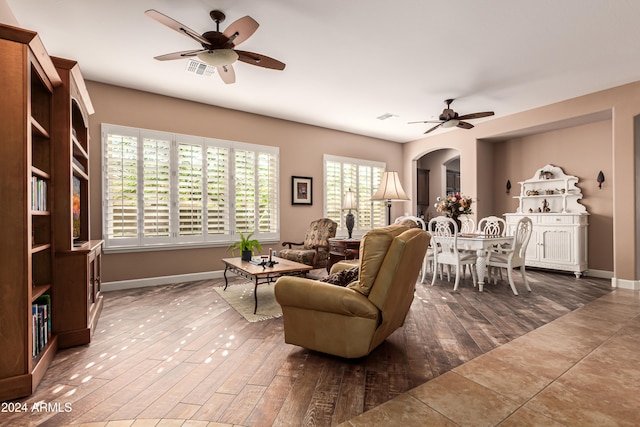 living room featuring ceiling fan and dark hardwood / wood-style flooring