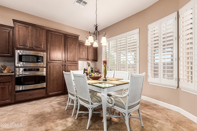 tiled dining area featuring a chandelier