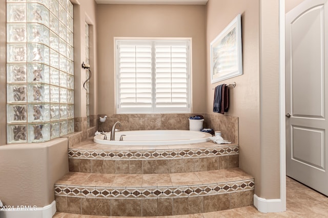 bathroom featuring tile patterned flooring and a relaxing tiled tub