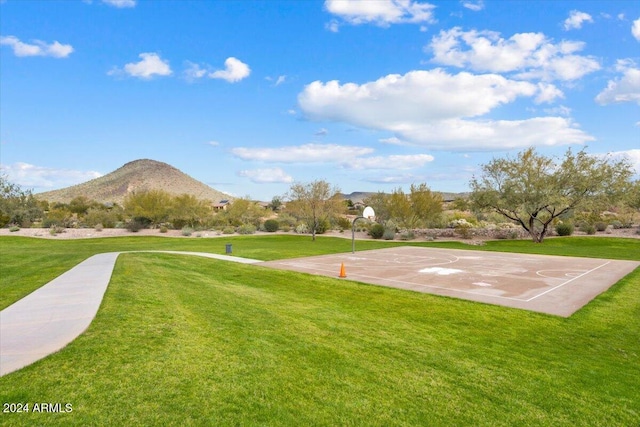 view of property's community featuring a mountain view, a yard, and basketball court