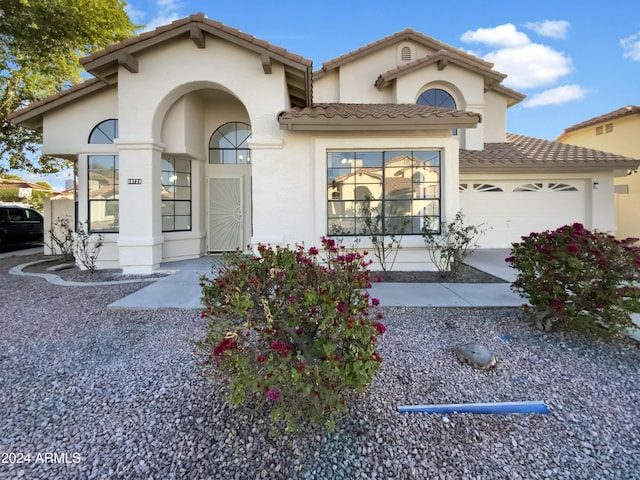 mediterranean / spanish-style home with a garage