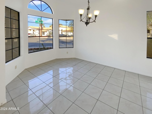 unfurnished dining area featuring light tile patterned floors and an inviting chandelier