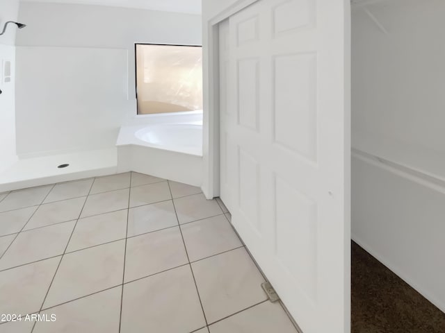 bathroom featuring tile patterned flooring and independent shower and bath