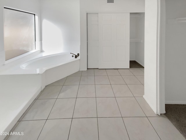 bathroom with tile patterned floors and a tub