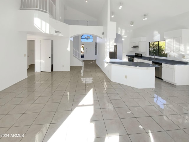 kitchen featuring white cabinetry, sink, high vaulted ceiling, light tile patterned floors, and appliances with stainless steel finishes