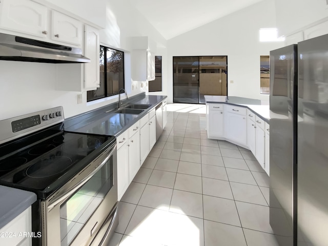 kitchen featuring stainless steel appliances, vaulted ceiling, sink, light tile patterned floors, and white cabinetry