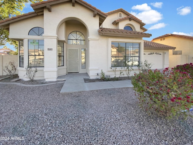 mediterranean / spanish-style home with a garage