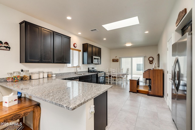 293 S Meadowood Ln, Sierra Vista, AZ 85635 - kitchen with appliances with stainless steel finishes, a sink, a skylight, light stone countertops, and a breakfast bar area