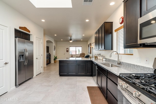 293 S Meadowood Ln, Sierra Vista, AZ 85635 - kitchen with stainless steel appliances, a sink, a peninsula, light stone countertops, and recessed lighting