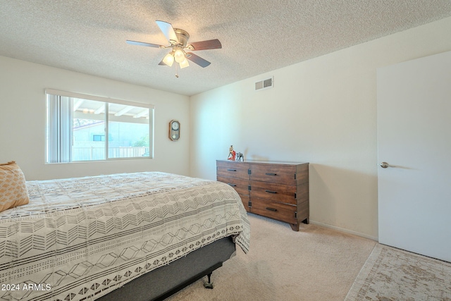 carpeted bedroom featuring a textured ceiling and ceiling fan