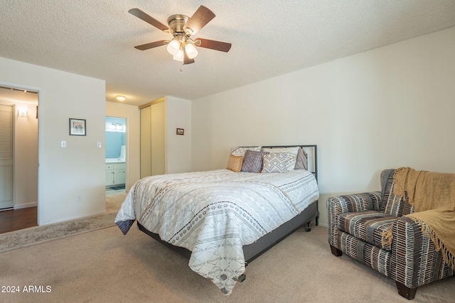 bedroom featuring a textured ceiling, light carpet, ceiling fan, and ensuite bath