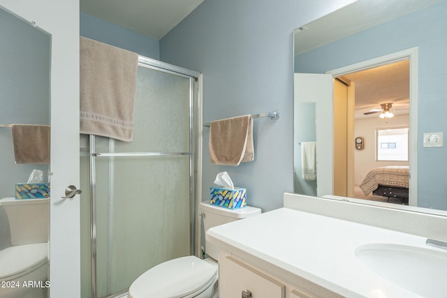 bathroom featuring walk in shower, vanity, toilet, and ceiling fan