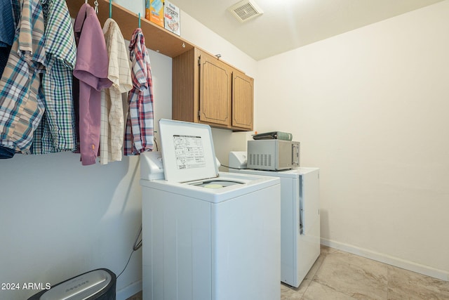 laundry room with cabinets and washer and dryer