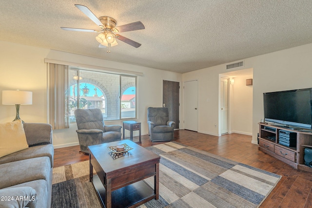 living room featuring a textured ceiling, hardwood / wood-style floors, and ceiling fan