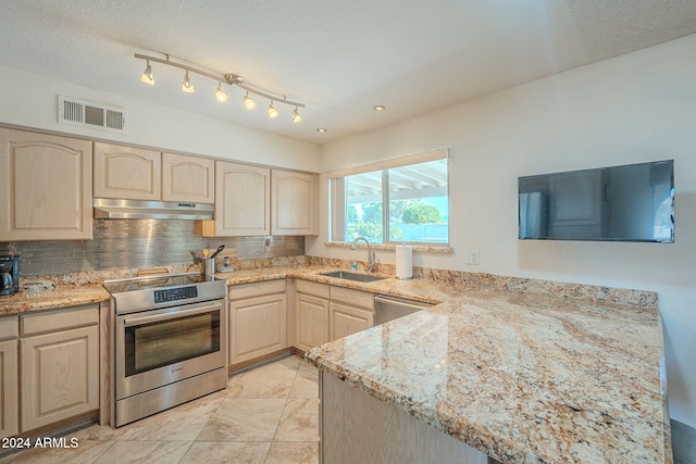 kitchen with a textured ceiling, stainless steel range oven, sink, backsplash, and light brown cabinetry