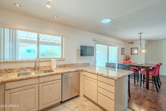 kitchen with dishwasher, kitchen peninsula, a textured ceiling, sink, and light wood-type flooring