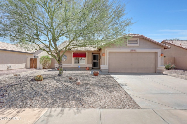 view of front of home with stucco siding, a garage, a tile roof, driveway, and fence