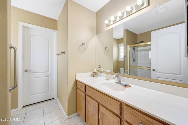 full bathroom with tile patterned floors, a stall shower, vanity, and baseboards
