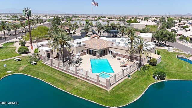 aerial perspective of suburban area with a pool and a large body of water