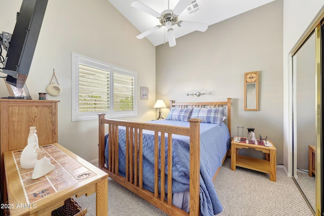 bedroom featuring light carpet, high vaulted ceiling, a closet, ceiling fan, and baseboards