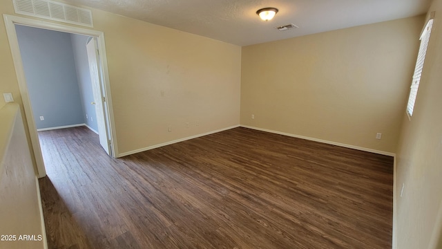 unfurnished room with dark hardwood / wood-style floors and a textured ceiling