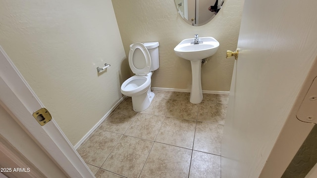 bathroom with tile patterned flooring, toilet, and sink