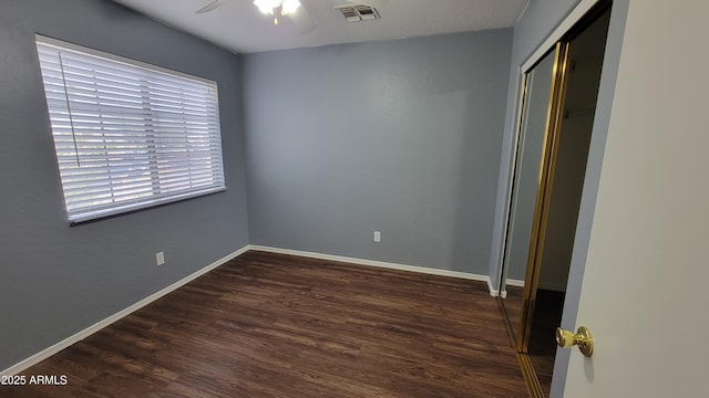 unfurnished bedroom with a closet, ceiling fan, and dark wood-type flooring