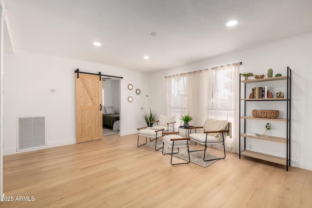 6835 E Friess Dr, Scottsdale, AZ 85254 - sitting room with a barn door, light wood finished floors, recessed lighting, and baseboards