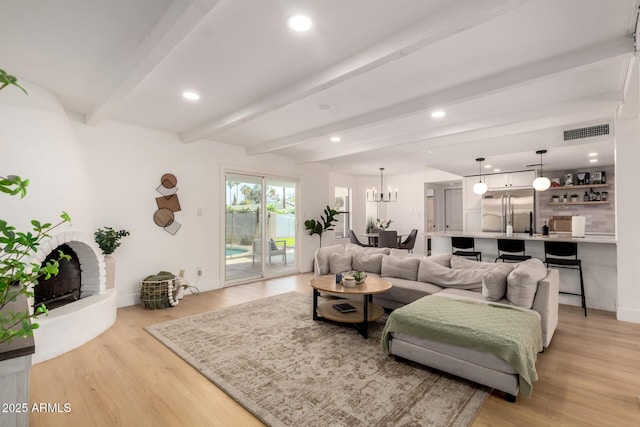 6835 E Friess Dr, Scottsdale, AZ 85254 - living room featuring beamed ceiling, light wood-type flooring, recessed lighting, baseboards, and a brick fireplace