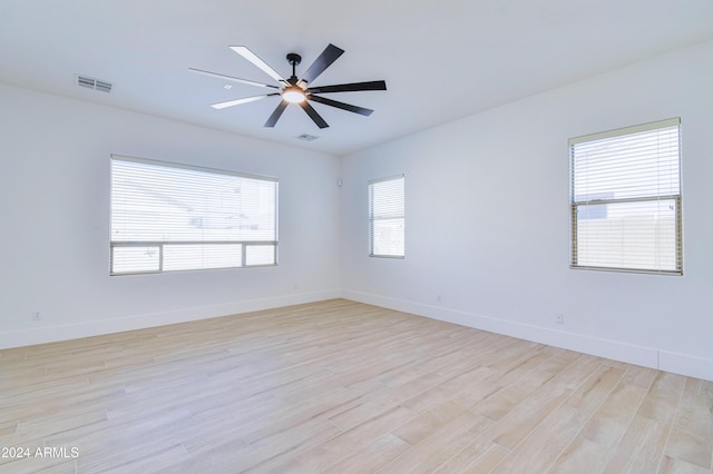 empty room with ceiling fan and light hardwood / wood-style flooring