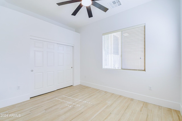 unfurnished bedroom featuring light wood-type flooring, a closet, and ceiling fan