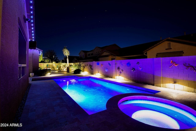 pool at twilight with an in ground hot tub