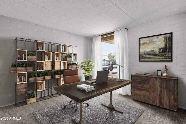 office with carpet flooring, a textured ceiling, and brick wall