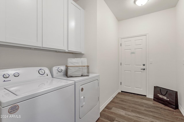 clothes washing area with hardwood / wood-style floors, cabinets, and washing machine and dryer