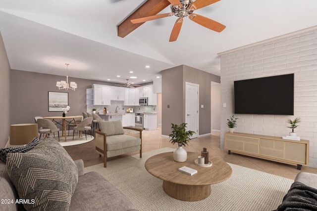 living room featuring ceiling fan with notable chandelier, sink, light tile patterned flooring, and vaulted ceiling with beams