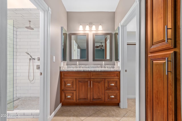 bathroom with tiled shower, vanity, and tile patterned flooring