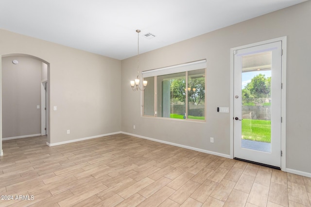 unfurnished room with light hardwood / wood-style floors and a notable chandelier