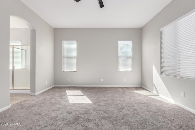 carpeted spare room featuring ceiling fan