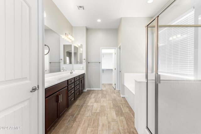 bathroom featuring separate shower and tub and vanity