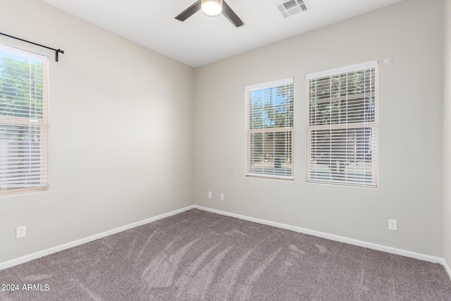 carpeted empty room with a wealth of natural light and ceiling fan
