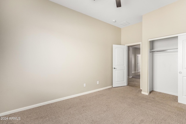 unfurnished bedroom featuring light carpet, a closet, and ceiling fan
